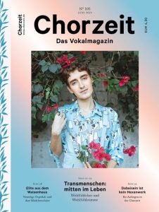 Chorzeit Nr. 105 (Juni 2023) Eine Person in einem gemusterten Hemd steht vor einer Wand mit blühenden rosa Blumen. Die Ausgabe widmet sich Transmenschen im Chor, Mädchenchören und Wohlfühlstimme.