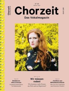 Chorzeit Nr. 69 (März 2020) Cover mit beigem Hintergrund: Eine Frau mit langen Haaren steht vor einem gelb blühenden Busch, trägt ein dunkles Kleid mit Blumenmuster. Themen sind Beethoven, Frauen im Chor und Schätze aus Mitteldeutschland.