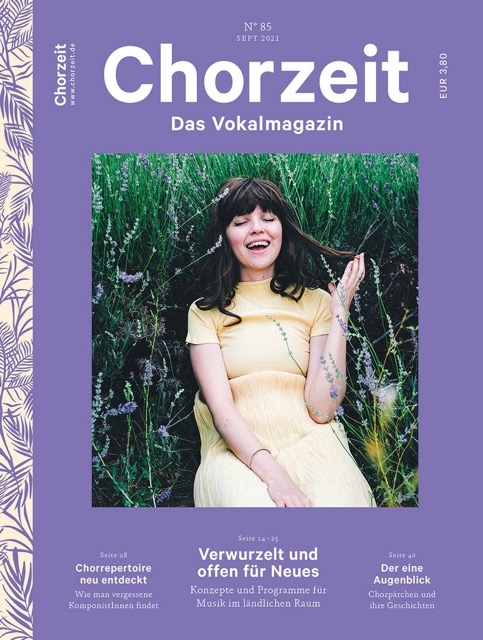 Chorzeit Nr. 85 (September 2021) Eine Frau in einem hellen Kleid liegt auf einer Wiese und hält einen Grashalm in der Hand. Die Ausgabe thematisiert Musik im ländlichen Raum, neue Komponistinnen und Chorporträts