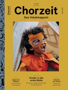 Chorzeit Nr. 88 (Dezember 2021) Ein Kind in einem orangefarbenen Kleid sitzt in einem Zelt aus hellen Stoffbahnen. Die Themen sind Mitmachkonzerte, Singen mit Demenz und lautes Schreien.