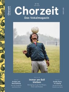 Chorzeit Nr. 92 (April 2022) Eine Person steht auf einem Fußballfeld und balanciert einen Ball auf dem Kopf. Die Themen sind Bewegung und ihre Wirkung auf Körper, Geist und Stimme.