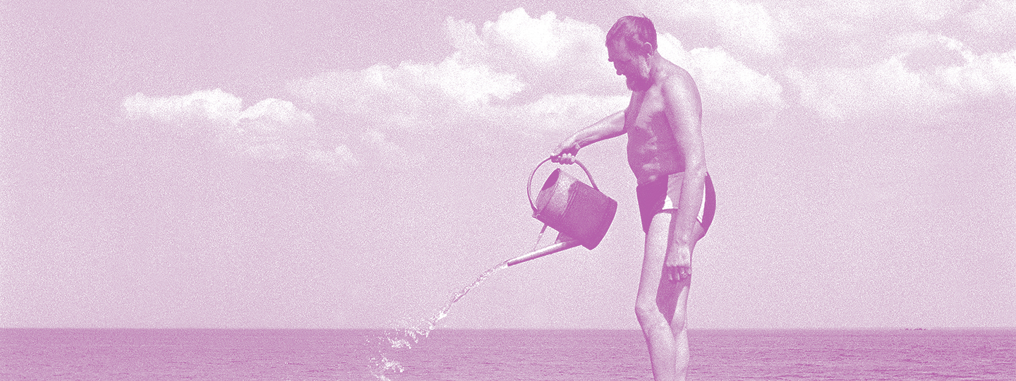 Der Komponist Veljo Tormis steht in Badehose auf einem Stein und gießt mit einer Gießkanne Wasser ins Meer.