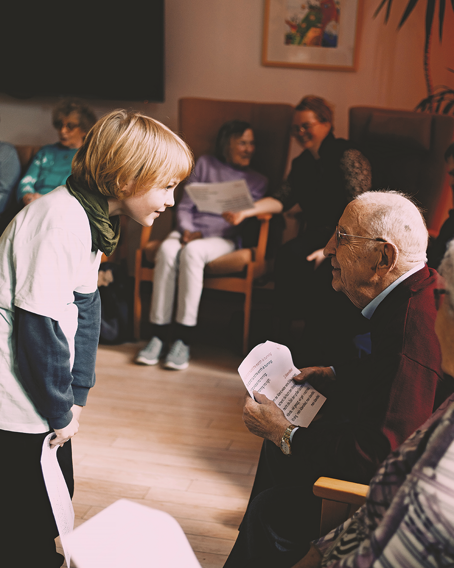 Ein junger und ein alter Mensch stehen einander gegenüber und schauen sich freundlich gegenseitig in die Augen.