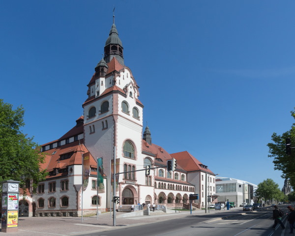 Die Kongresshalle am Zoo in Leipzig ist ein stattlicher Bau mit weißer Fassade und rotem Ziegeldach, das einer Kreuzung zugewandte Eck ist ein breiter Turm.